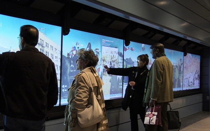 People using a digital touch wall.