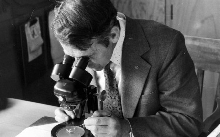 Lawrie Metcalf viewing plant material through a microscope.